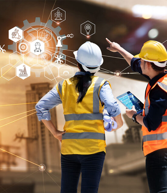 Two construction professionals in high-vis jackets and hard hats reviewing project data at a construction site.